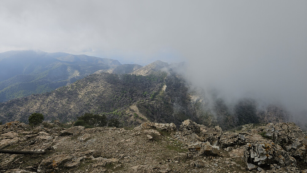 Tilbake mot turens første topp som nesten er dekket av tåke, midt i bildet