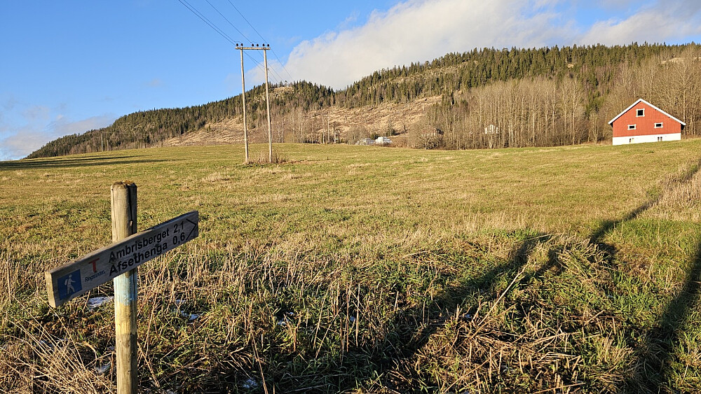 Skilt ved stistart med toppene i bakgrunnen