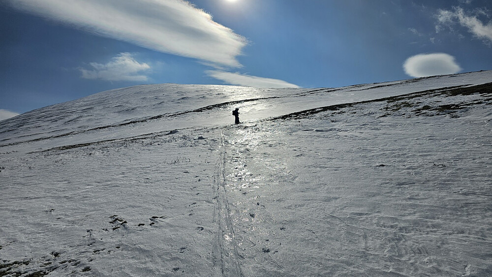 Etter en seig kryssing av dalen inn mot fjellet, begynte vi på motbakken opp ryggen. I starten var det litt vår snø, og når snøen ble tørrere høyere opp, kladdet det kraftig under skiene et stykke