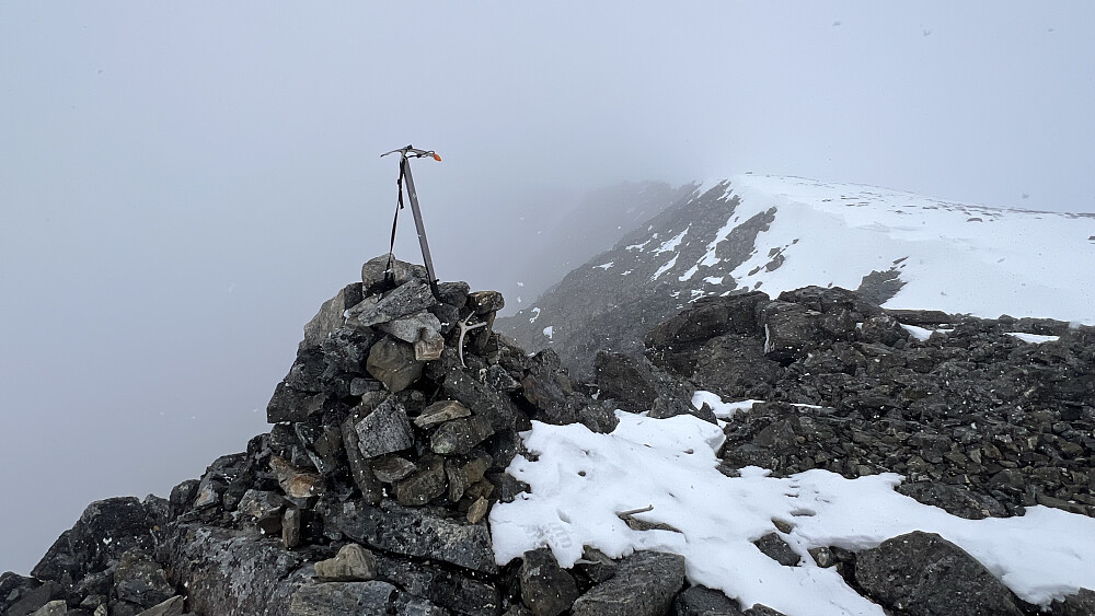 Isøksa mi fikk pryde toppvarden på Veslfjelltinden et øyeblikk som takk for solid tjeneste i å hjelpe meg å nå toppen. De hvite prikkene på bildet er snø - for det snødde på begge toppene da jeg var der