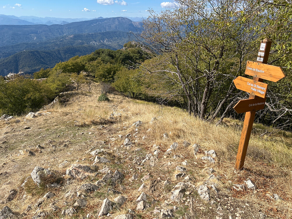 Skilt med stistart for den bratte stien ned til Col de la Madone.