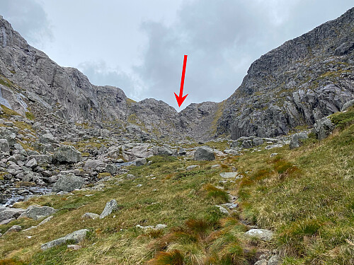 Bilde #7: Eikedalen ender på en måte med en fjellvegg på alle kanter. Stien ut av dalen, og opp på platået ovenfor, går opp gjennom skaret markert med den røde pila.