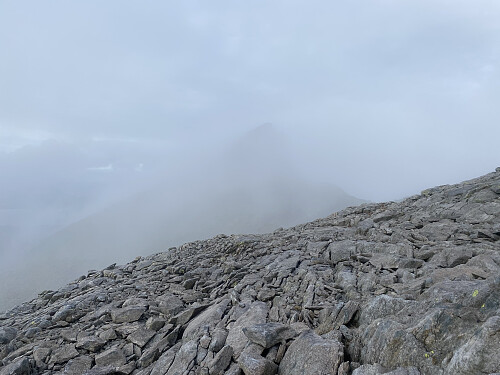 Bilde #22: På vei ned fra Ulvanosa, og Geitadalstinden [1211 m.o.h.] kommer til syne i tåka.