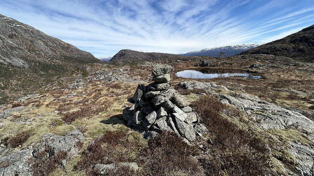 Varden på Trollhaugen. Foto mot øst. Høyeste punkt på en liten knaus øst for varden. Sauafjellet 539 i Os i bakgrunnen