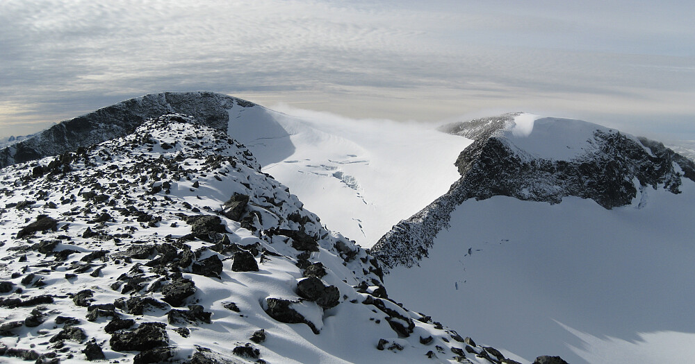 Sammensatt bilde som viser den bratte skråningen fra Hurrbreatinden ned mot bandet mellom Hurrbrean i bakgrunnen og Veslbrean  og Bakerste Skagsnebb foran mot høyre. Veslfjelltinden 2157 i bakgrunnen mot venstre.