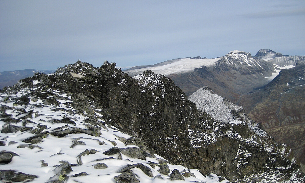 Bakarste Skagsnebb toppene mot venstre. Ryggen på Fremste Skagsnebb mot høyre. Skardstinden, Ymelstinden og Galdhøpigg-massivet i bakgrunnen