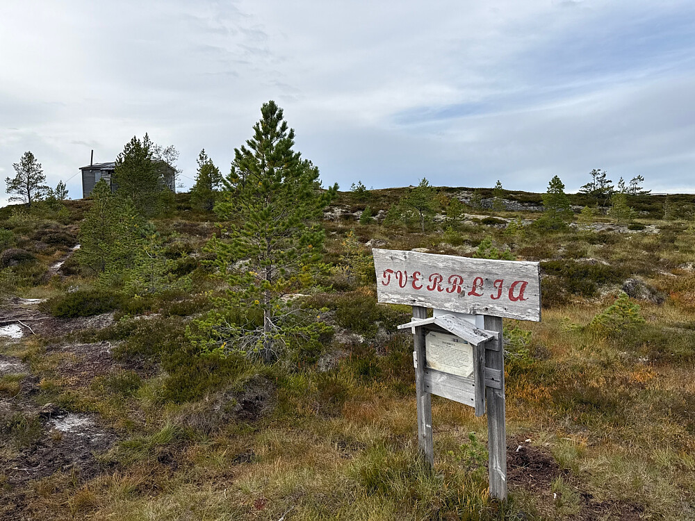 Hytte på toppen med historisk info på en plakat