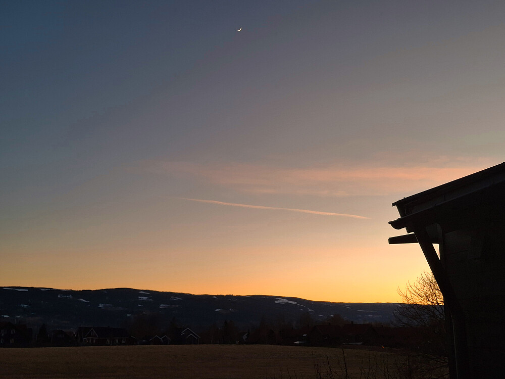 Kveld i Blestervegen, sola går ned og en liten måne