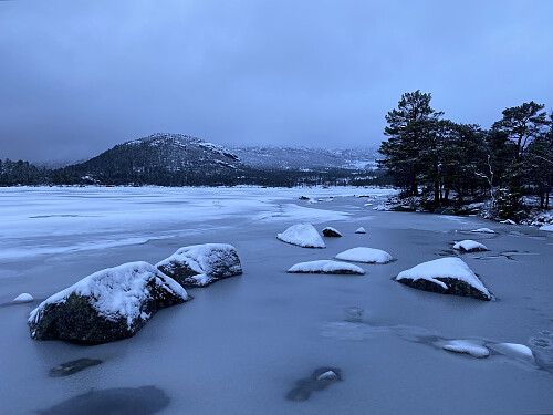Det nærmar seg kveld ved Forenesvatnet. Solknuten ligg under skoddelaget