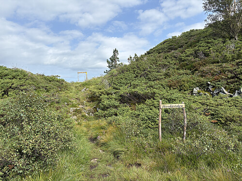 Ved Hovdastølen. Utsiktspunktet er bak til venstre, stien opp mot toppen går opp til høyre