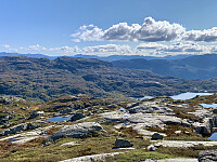 Utsikt sørover. Vi ser fjellene syd for Hylsfjorden i bakgrunnen. Aller bakerst ser vi bl.a. Snønuten, Napen og Gullingen. Til venstre ser vi Hestfjellet og til høyre ser vi Grimsvatnet.
