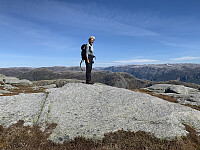 Toppen uten varde. I bakgrunnen ser vi de bratte veggene på sørsida innover i Lysefjorden. Hardhausen til venstre i bildet.