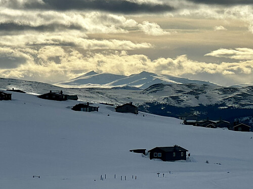Nede igjen ved toppen av Tjønnbakken, med utsikt over Jotunheimen og Nautgardstinden og nubbene som skinner i kveldssola.