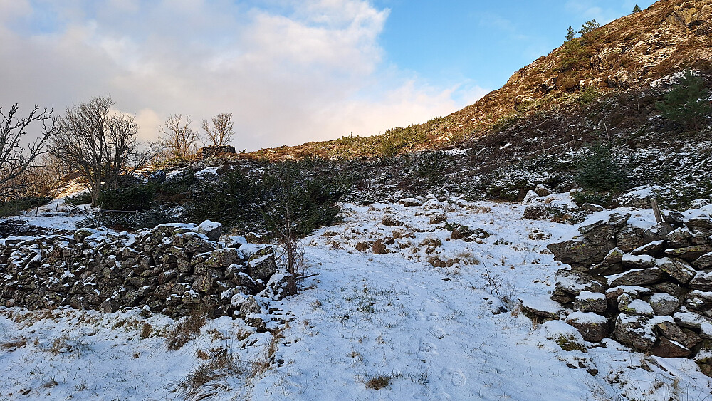 Gammel steinbygd kjerrevei de første hundre meterne av turen. Solgløtt på vei ned. 