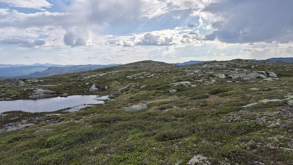 Jeg er oppe på det slake platået på Nordre Olabunut hvor det er flere mindre høyder og små tjern. Toppvarden er nå synlig på høyeste punkt (1252), som er haugen midt i bildet. Veldig lett å gå her oppe.