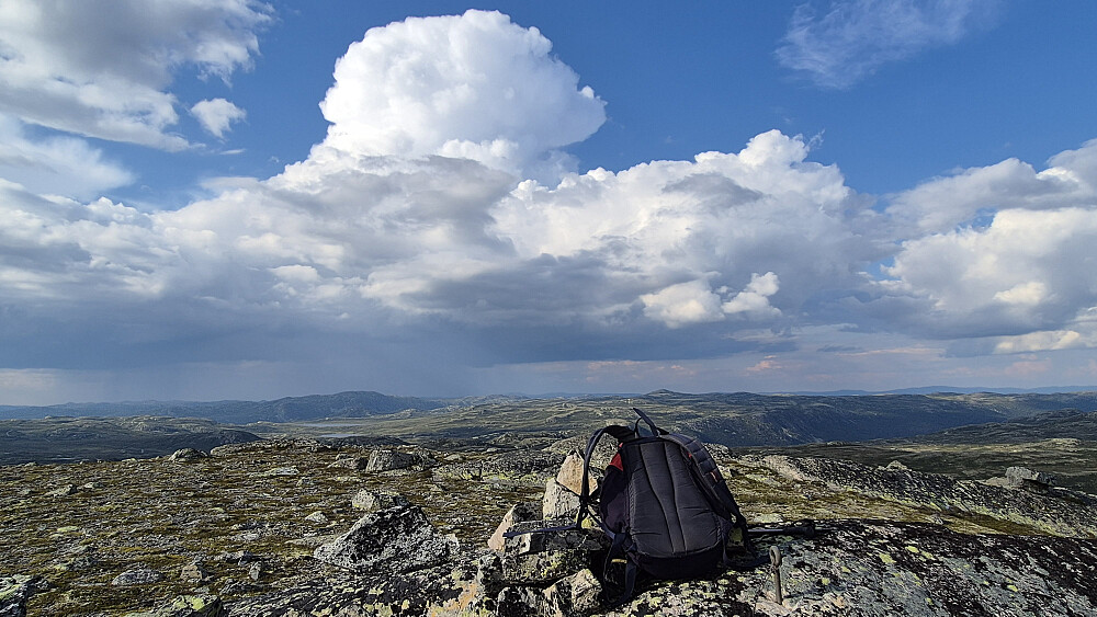 Sekken min står inntil toppvarden på Nordre Olabunut trig. punkt (1252). Bildet tatt mot nord/nordøst. Den store bygeskyen (cumulonimbus) i bakgrunnen hadde i følge lynradaren på Yr gitt fra seg ganske mange lyn. Glad jeg ikke var på tur der den traff!