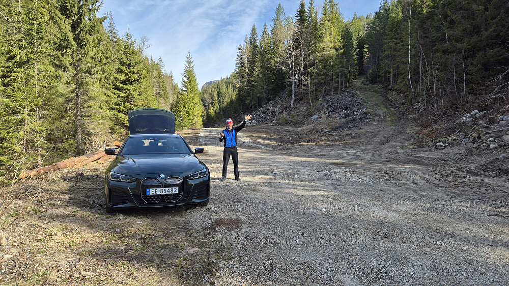 Haslestad parkering. Stien starter på traktorveien som går oppover i skogen til høyre. I bakgrunnen og nesten rett over Hans Petter, ses toppen av Rønnomnibben (615). Da vi sto der oppe så vi faktisk bilen her på parkeringen.